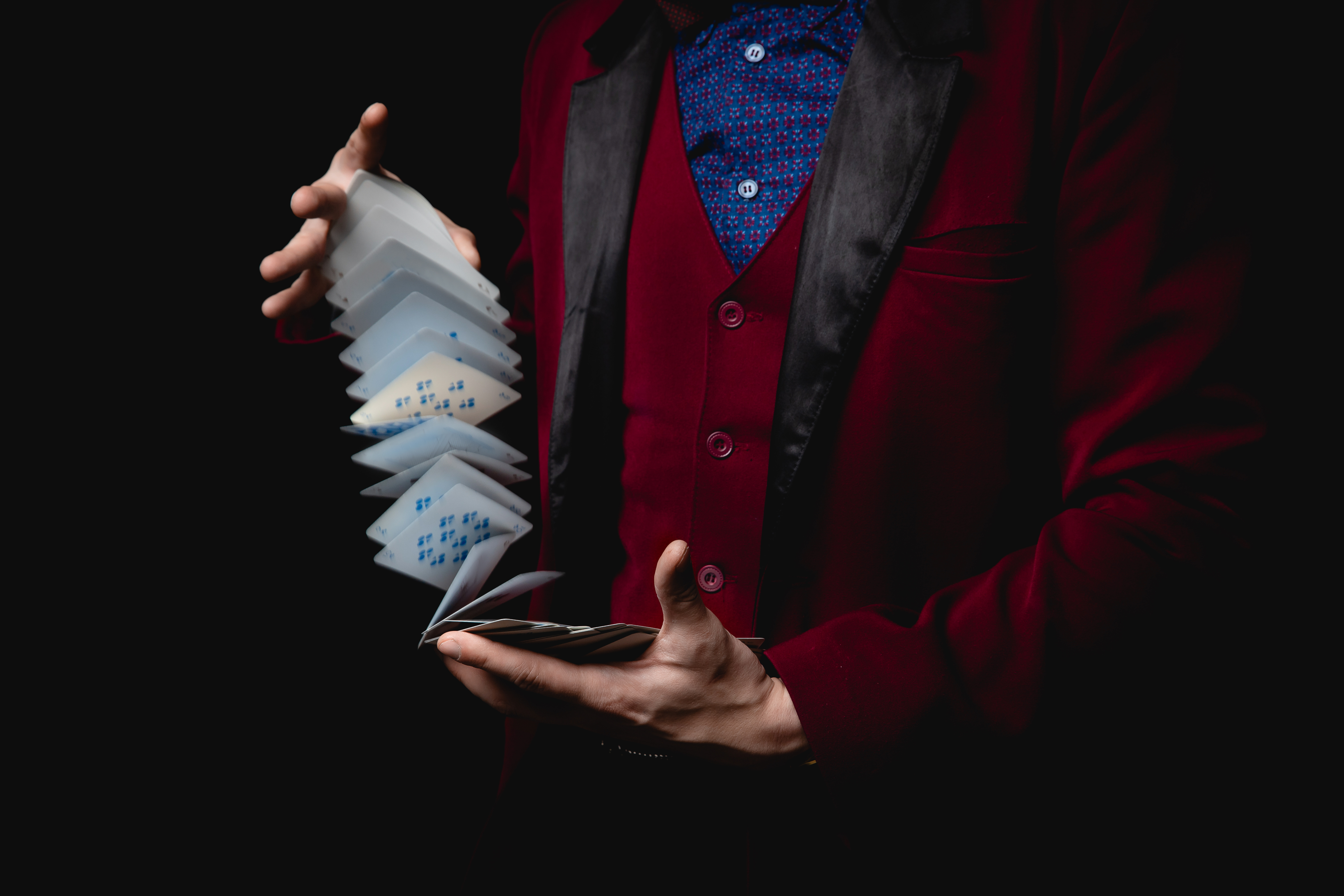 A Janeda Magician performing a close-up card trick at a table with amazed onlookers